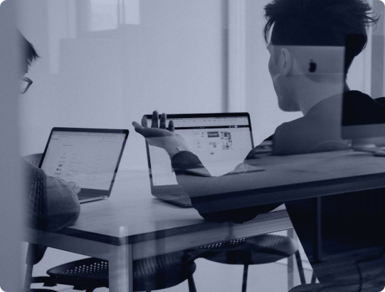 Two colleagues reviewing an application on their laptops